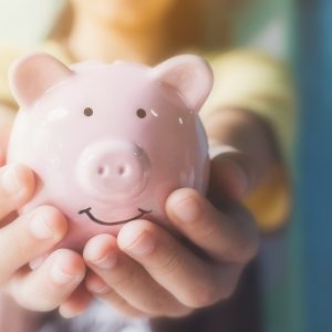 Female hand holding piggy bank. Save money and financial investment